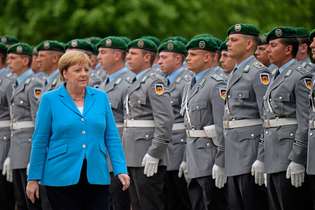 Angela Merkel passa pela tropa da chancelaria em Berlim: tremores recorrentes e dificuldades no governo
