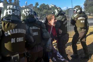 Manifestante é detida durante protesto, na tarde desta sexta-feira, em Santiago
