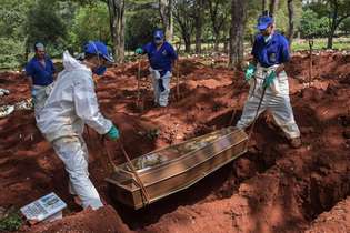Funcionários enterram uma pessoa que morreu com suspeita de coronavírus no cemitério de Vila Formosa, nos arredores de São Paulo