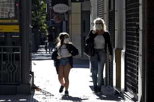 Mulher e menina usam máscaras enquanto caminham em Buenos Aires durante a pandemia de coronavírus