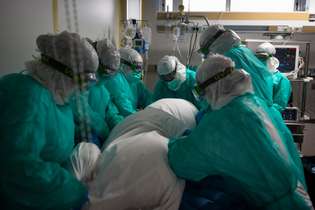 Em Vigo, na Espanha, profissionais de saúde se preparam para transferir paciente para a UTI