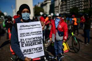 Centenas de entregadores, usando máscaras e em bicicletas, das multinacionais Glovo, Rappi e Uber percorreram uma avenida central em Buenos Aires