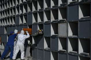 Funcionários selam gaveta que contém o caixão de uma vítima do coronavírus no Rio de Janeiro