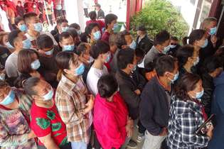 Chineses em fila para a vacinação: mais de 421,9 milhões de doses de vacinas foram inoculadas até esta terça
