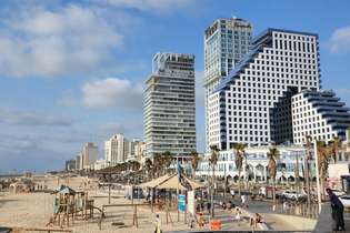 A praia de Tel Aviv e seus modernos edifícios: água morninha do Mediterrâneo mar e o coração pulsante da cidade