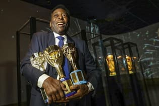 Pelé posa para foto ao carregar as três taças de Campeão do Mundo conquistadas com a seleção brasileira