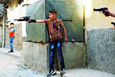 Vida violenta. Crianças sírias brincam com armas de brinquedo em Aleppo, onde ontem houve novo bombardeio