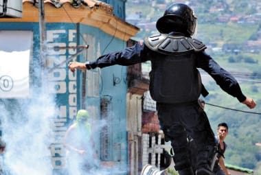 Tensão. Policial lança bomba de gás contra manifestantes em San Cristobal, Estado de Tachira