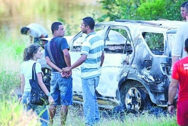 
Carro de casal morto  foi achado todo queimado; na foto, suspeito (de blusa preta) fazia reconhecimento 
