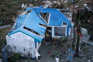 Moradores vasculham os escombros de sua casa danificada