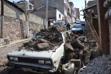 Um carro estacionado sofreu danos quando uma parede desabou sobre ele depois do forte terremoto