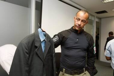 Delegado Ramon Sandoli apresenta roupa que o promotor vestia e que está com buracos de tiros